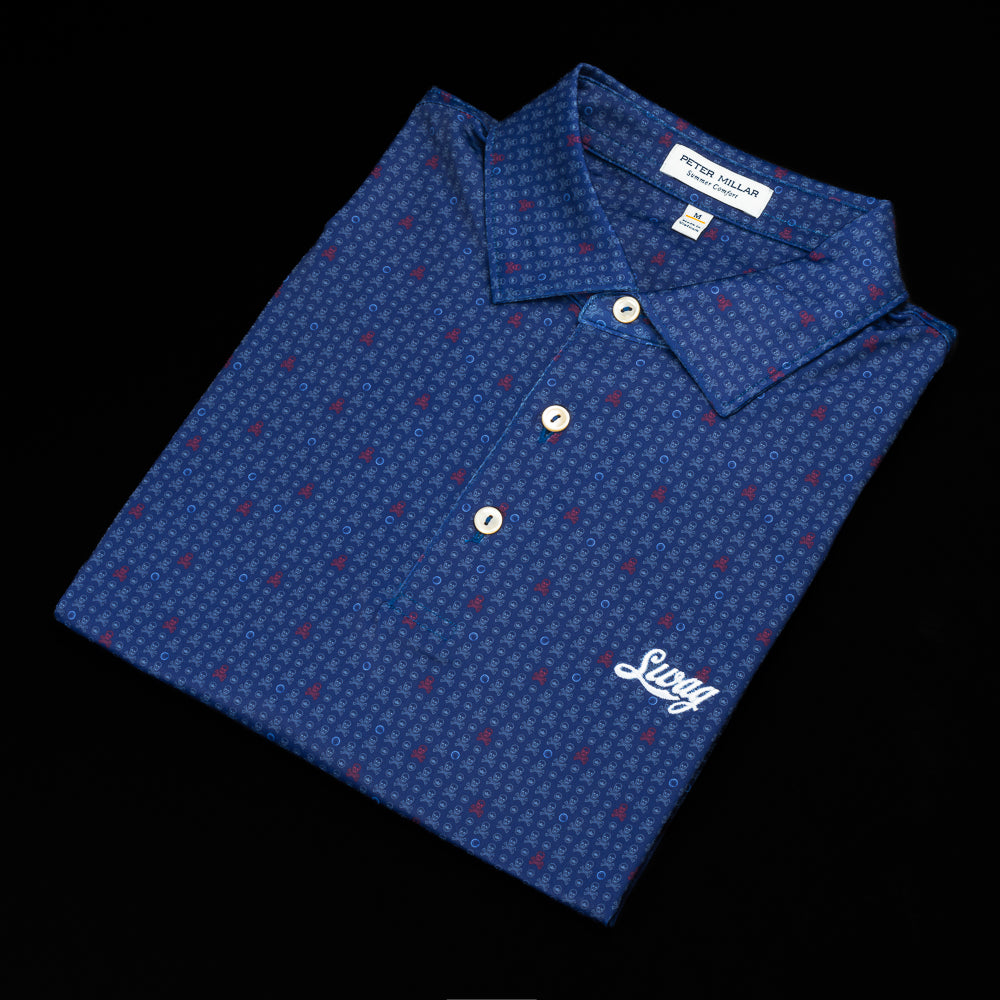 Navy blue Peter Millar polo with red and blue skull and cross bone pattern. And white Swag logo on the left chest.