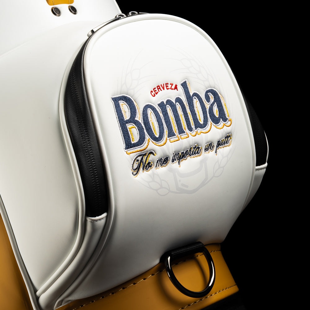 Close-up of the Bomba embroidered logo and zipper pocket detail on the white leather den caddy.