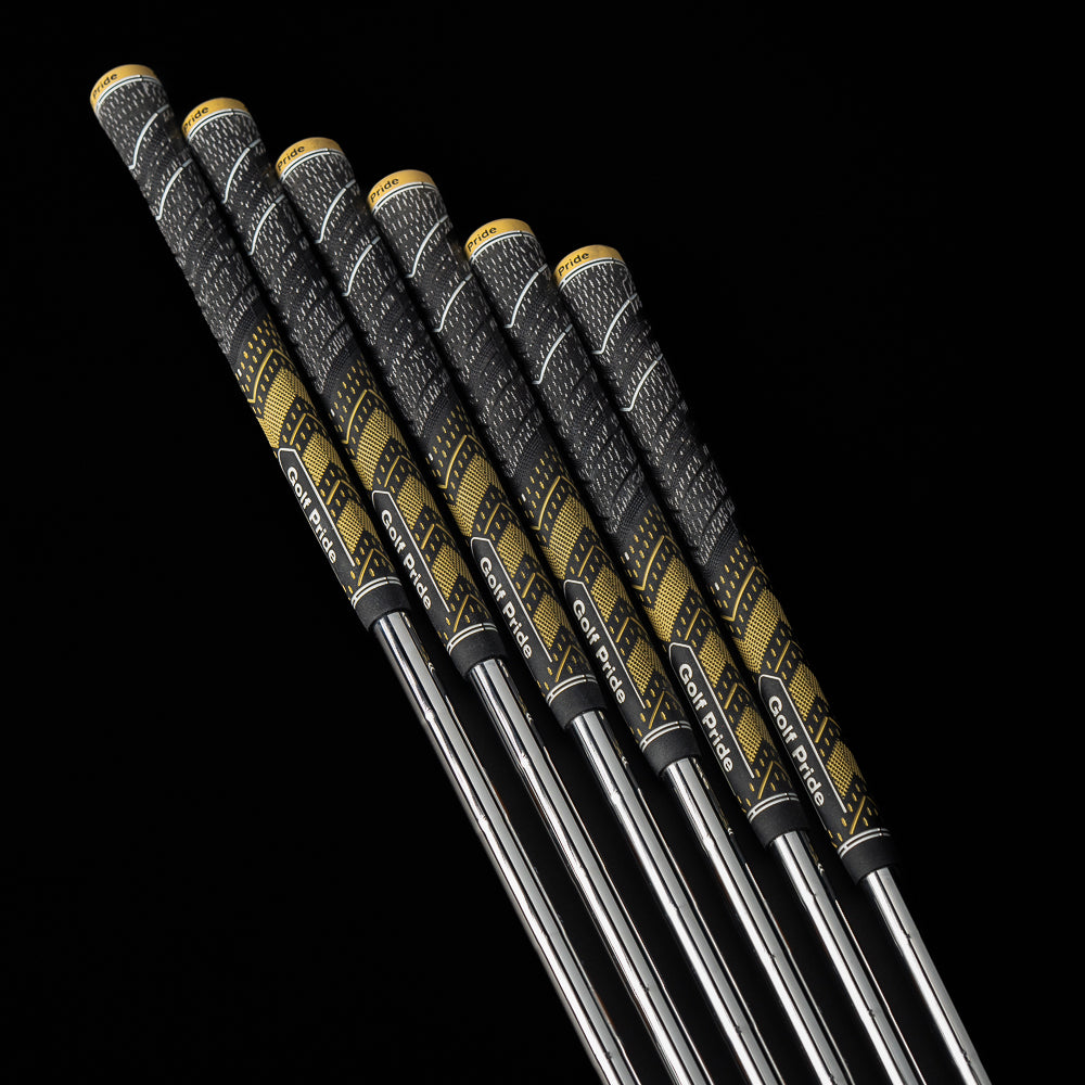 Four golf clubs with black and gold grips on a black background