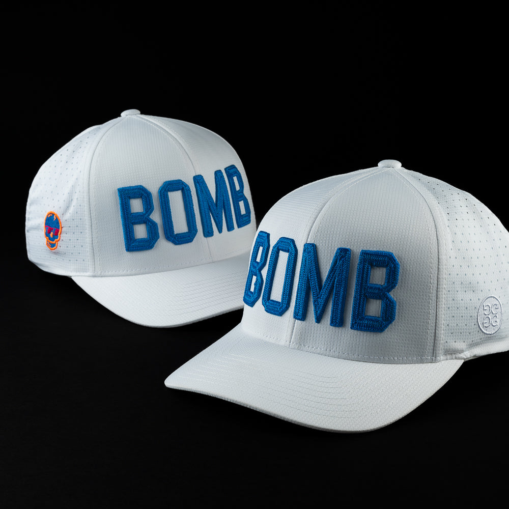 SWAG Golf x G/Fore white performance golf hat with blue BOMB letters on the front.