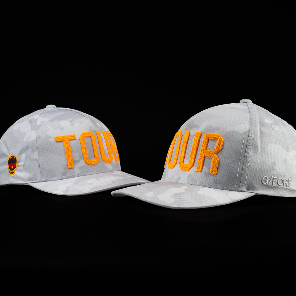 G/FORE Tour Flexfit men's performance golf hat in white and gray camouflage and orange Tour with orange and black skull.