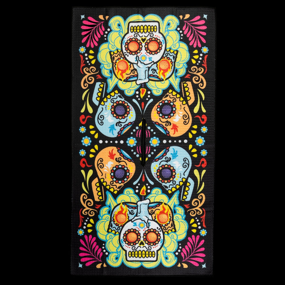 Día de los Muertos golf towel featuring colorful sugar skulls and floral pattern on black background by SWAG Golf.