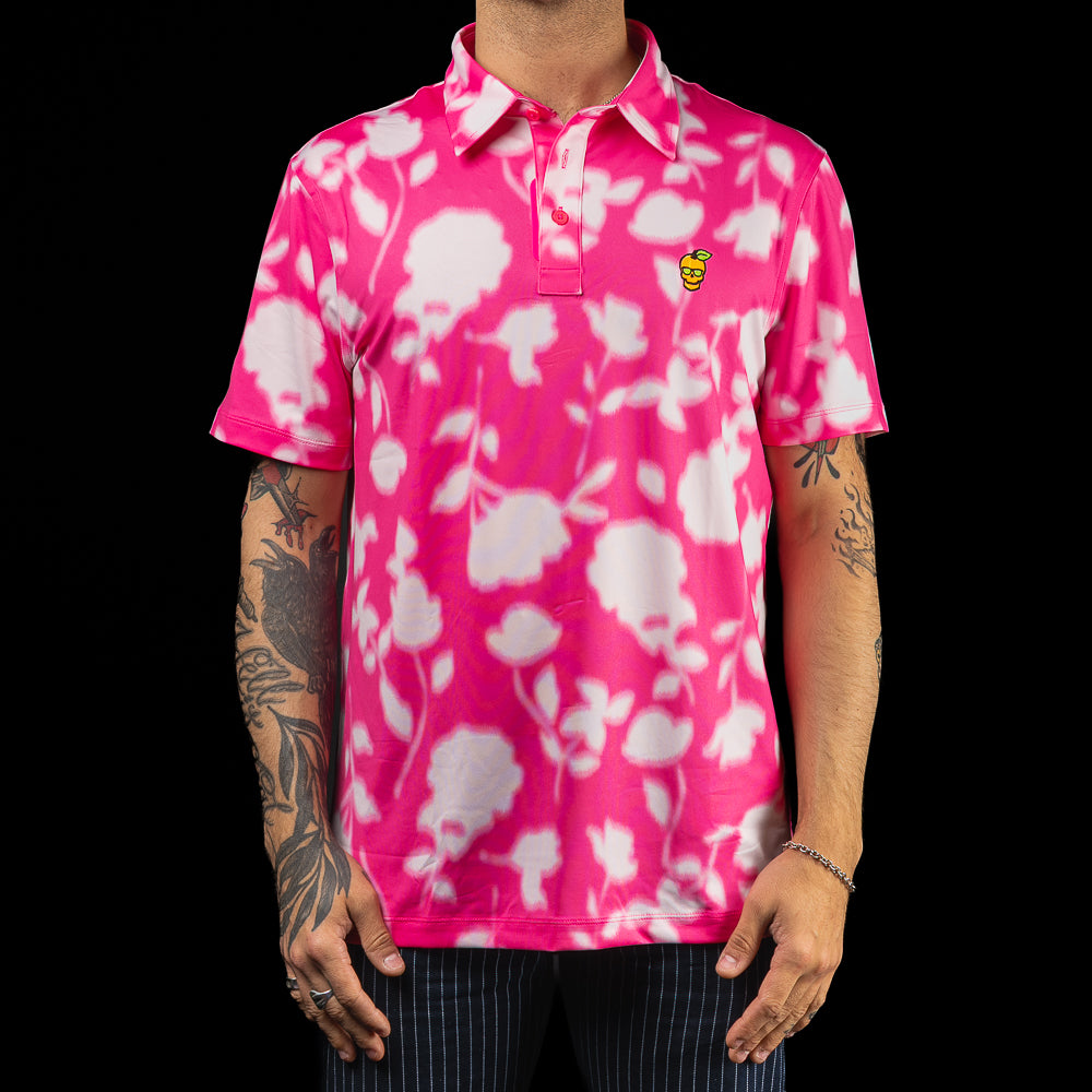 SWAG Golf x G/FORE men's performance golf polo shirt with pink and white floral pattern and a peach skull logo over the left chest.