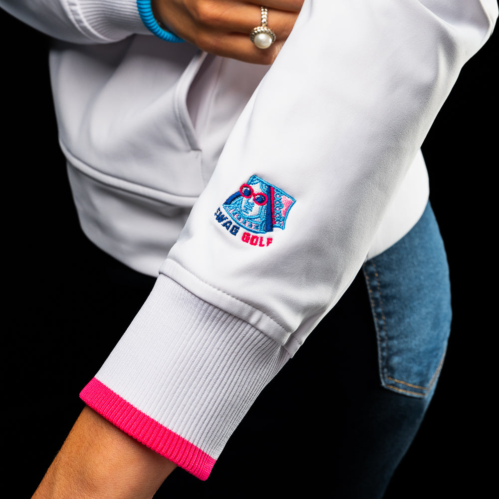 SWAG Golf x G/FORE women's long sleeve white quarter zip with blue and pink accents.