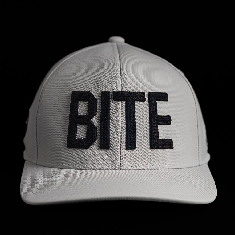 SWAG Golf x G/FORE white flexfit 110 snapback golf hat with BITE letters on the front.