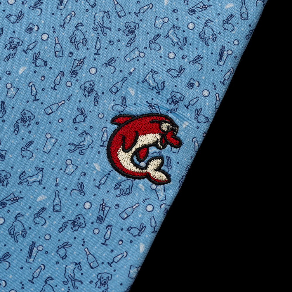 SWAG x Peter Millar blue men's golf polo with animal and cocktail print with red flipper.