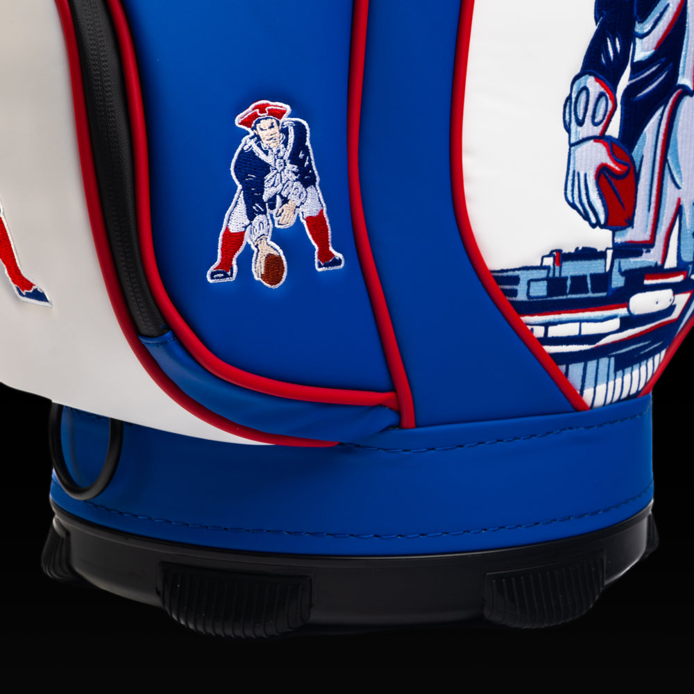 Close-up of the embroidered Pat Patriot logo on the front pocket with the vintage mascot artwork in the background.
