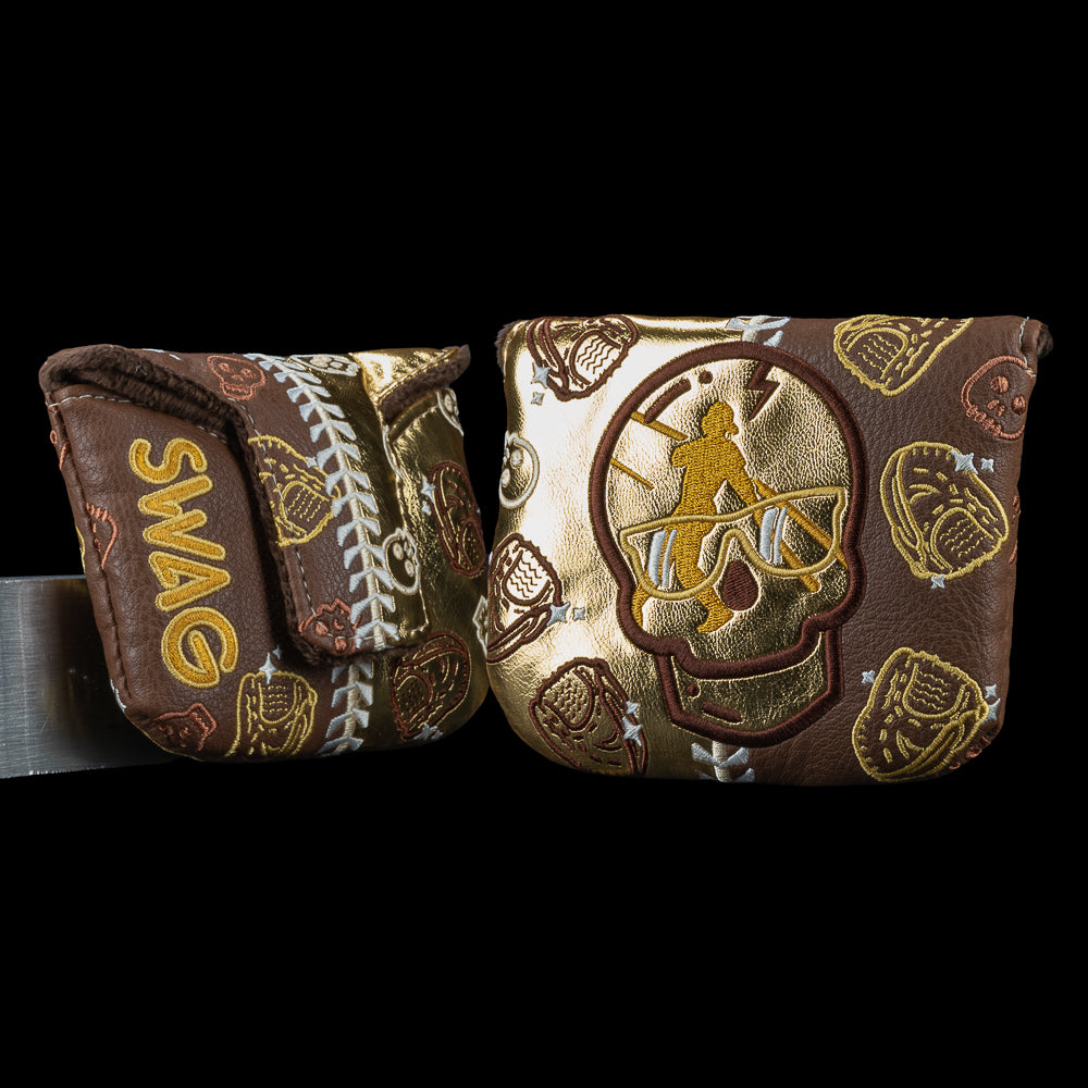 Gold and brown Swingman Skull mallet putter cover with metallic skull icons, baseball gloves, and batter swing silhouette.