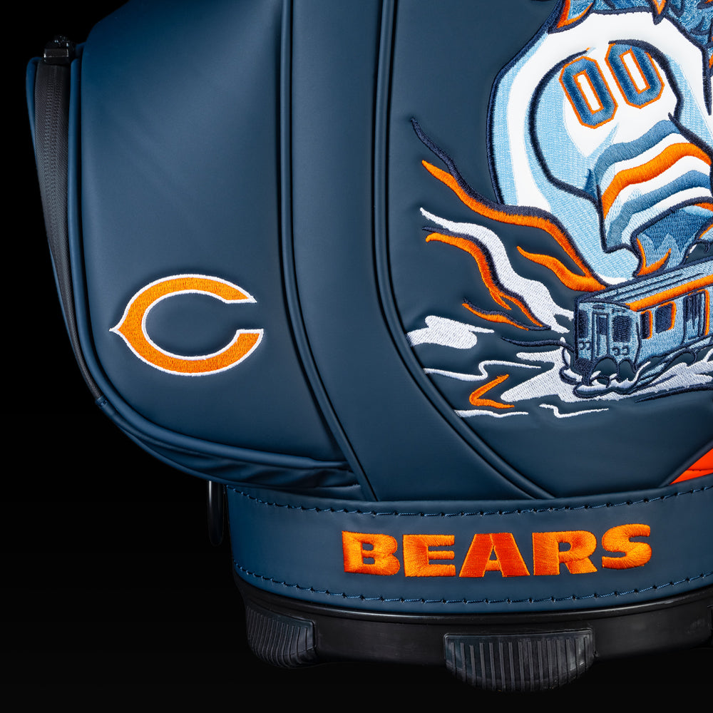 Close-up of the embroidered Chicago Bears logo on the front pocket with "Monsters of the Midway" artwork in the background.
