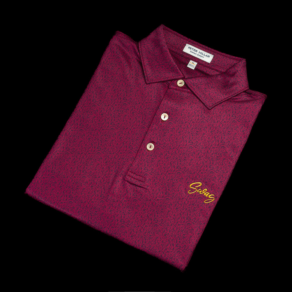Burgundy Peter Millar men's short sleeve golf polo shirt with yellow SWAG on the left chest and cigar on the left sleeve.