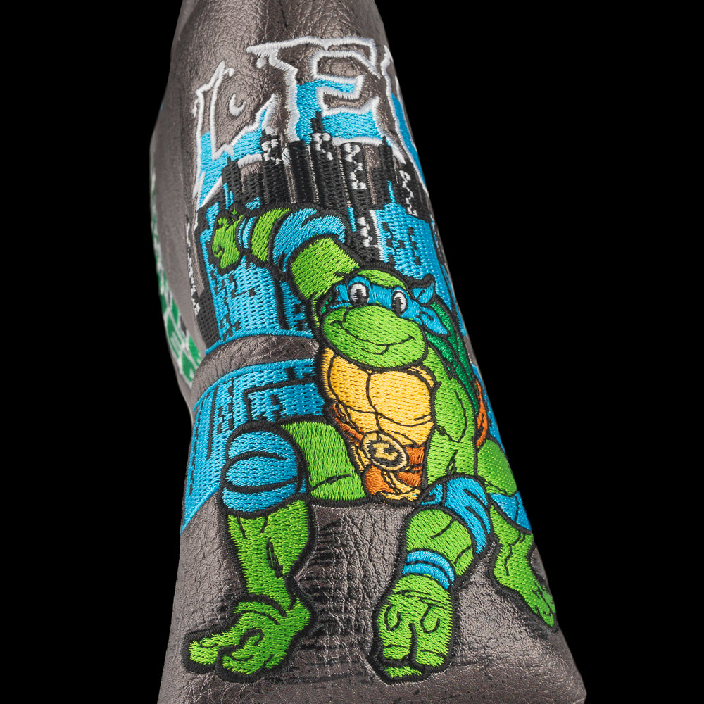 TMNT Leo blade putter cover with swords and blue cityscape detailing.