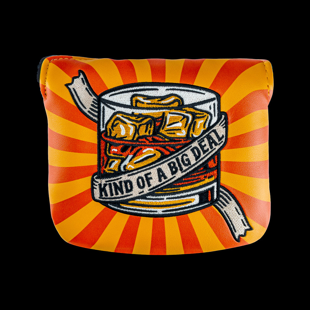 Rewind Golf x Anchorman mallet golf headcover with a graphic design of a glass of whiskey with 'Kind of a Big Deal' text on an orange and red striped UV material.