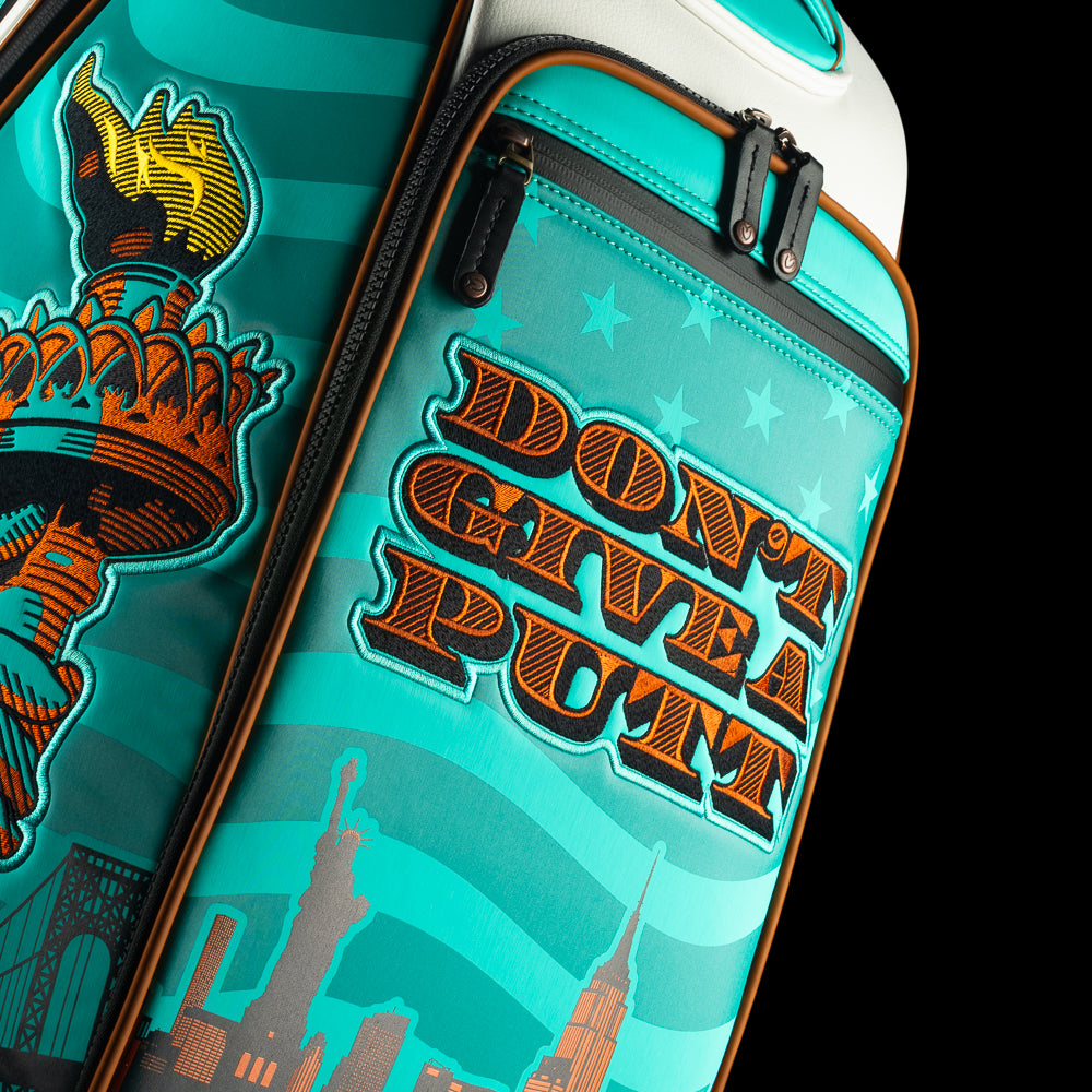 SWAG x Vessel golf bag with Statue of Liberty design and 'Don't Give a Putt' text on a black background