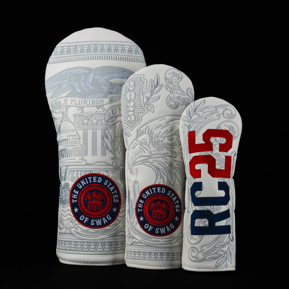 Three Ryder Cup 2025 official white golf club headcovers with detailed designs and 'The United States of Swag' branding on a black background.