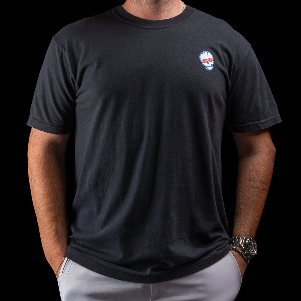 Person wearing a black t-shirt with a skull logo on a black background