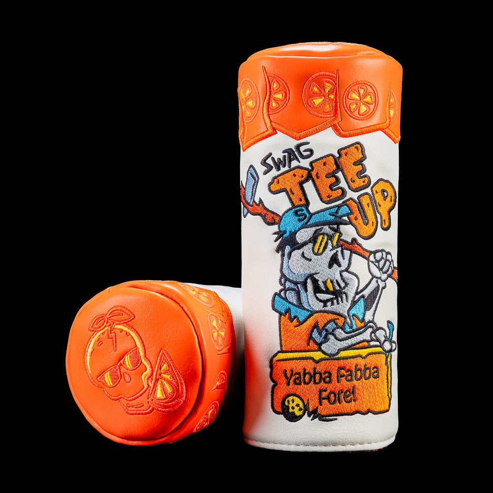 Fairway wood cover designed like a vintage style vitamin package featuring a cartoon stone age golfer, bright orange graphics, and SWAG Golf branding.
