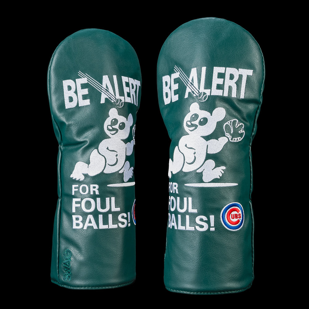 Chicago Cubs driver headcover inspired by the iconic Wrigley Field "Be Alert for Foul Balls!" sign featuring the Cubs bear mascot, bold white lettering, Cubs logo, and dark green design.