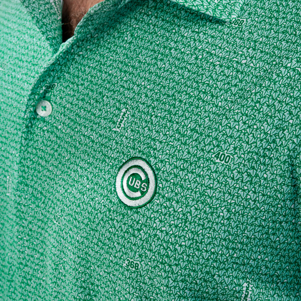 Close-up of a green ivy patterned polo shirt with a visible Cubs logo patch on the chest.