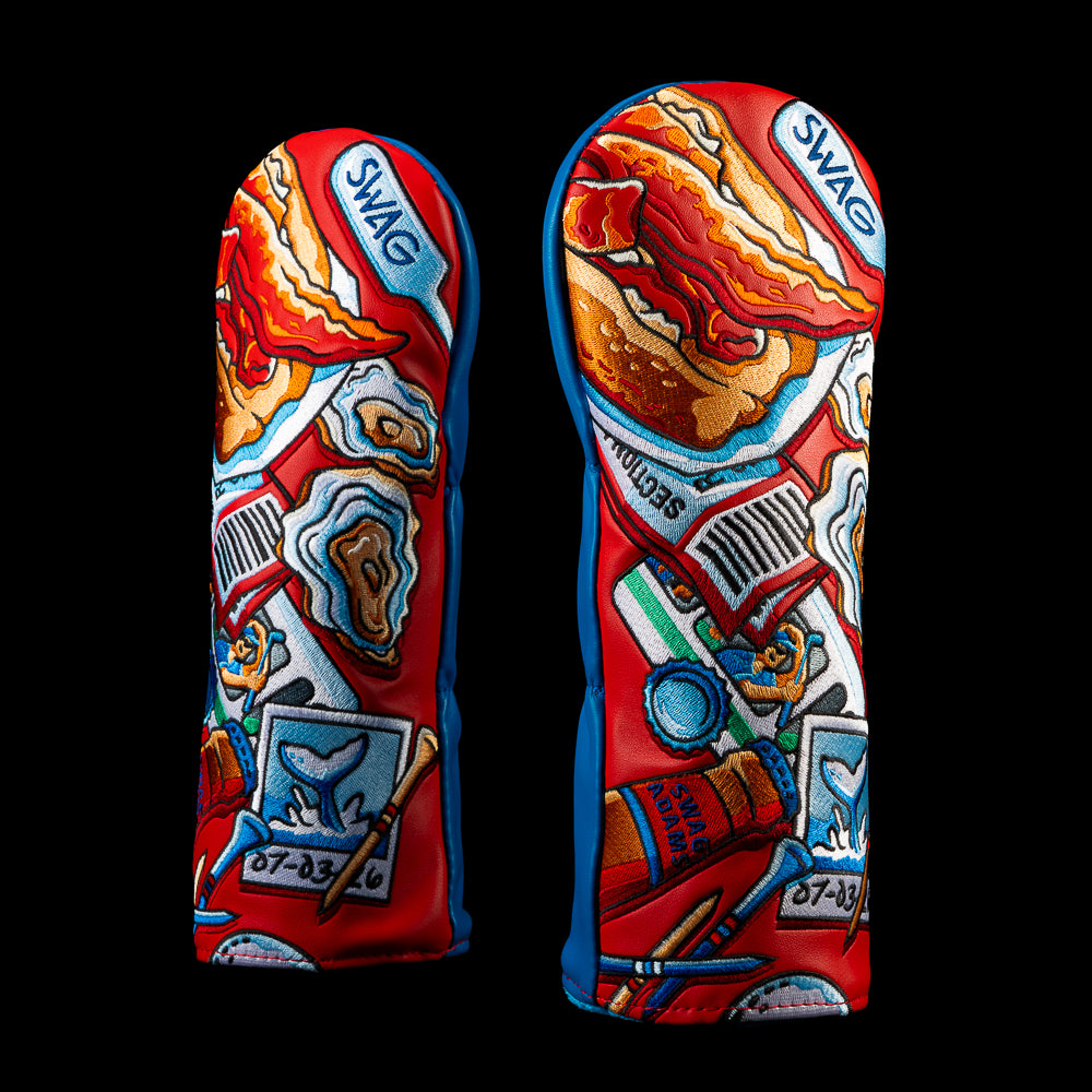 Front and back views of the SWAG Golf Boston Essentials fairway wood cover featuring colorful embroidered Boston artwork with lobster roll, oysters, waterfront details, and local icons in red, blue, cream, and gold.
