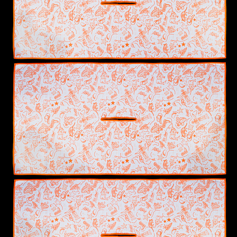Texas golf towel featuring an all-over pattern of hand-drawn Texas-inspired illustrations including cowboy boots, longhorns, tacos, cacti, armadillos, stars, and other Lone Star icons in orange on a white background.