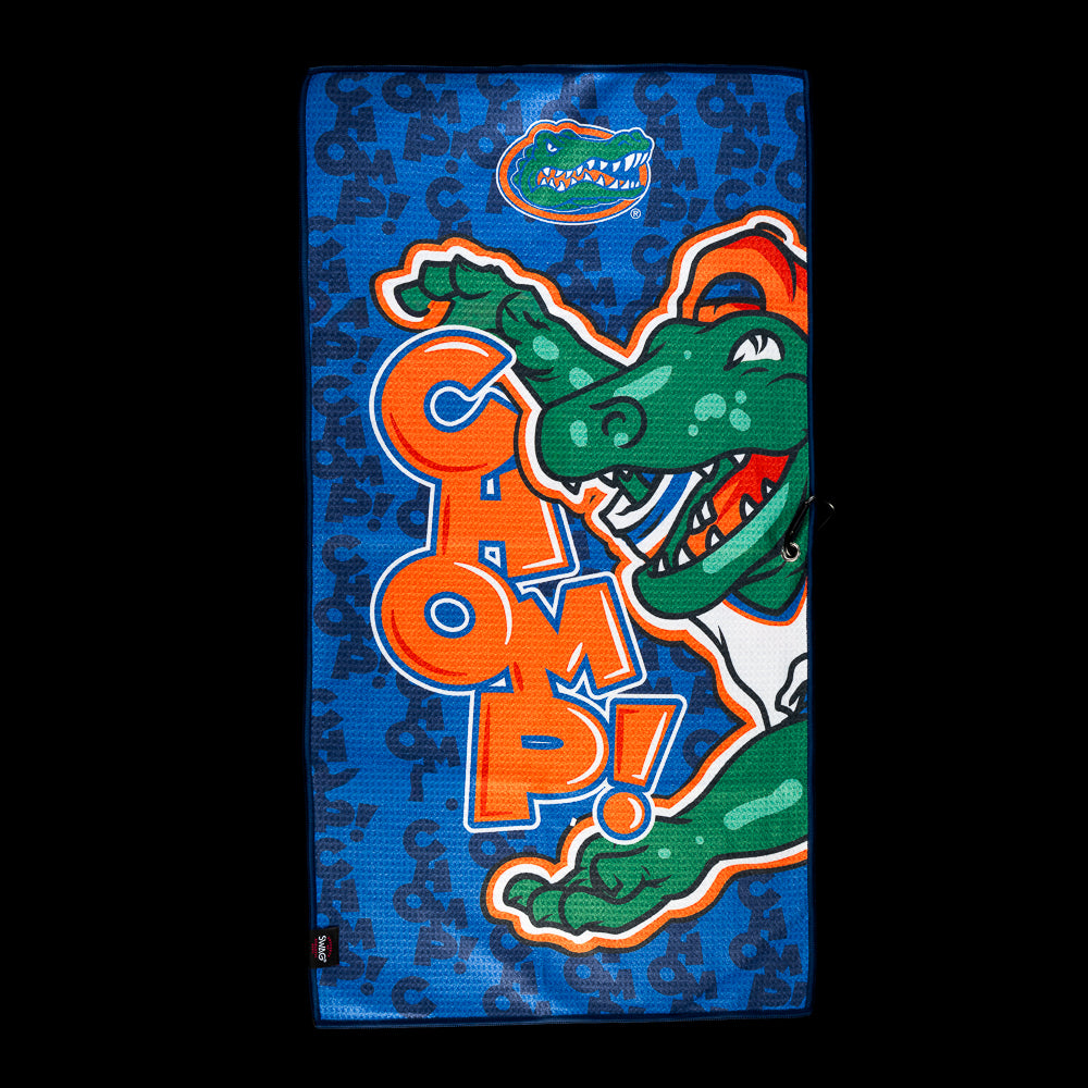 SWAG Golf University of Florida The Chomp Golf Towel featuring an illustrated gator, “CHOMP!” lettering and a blue lettered background pattern.