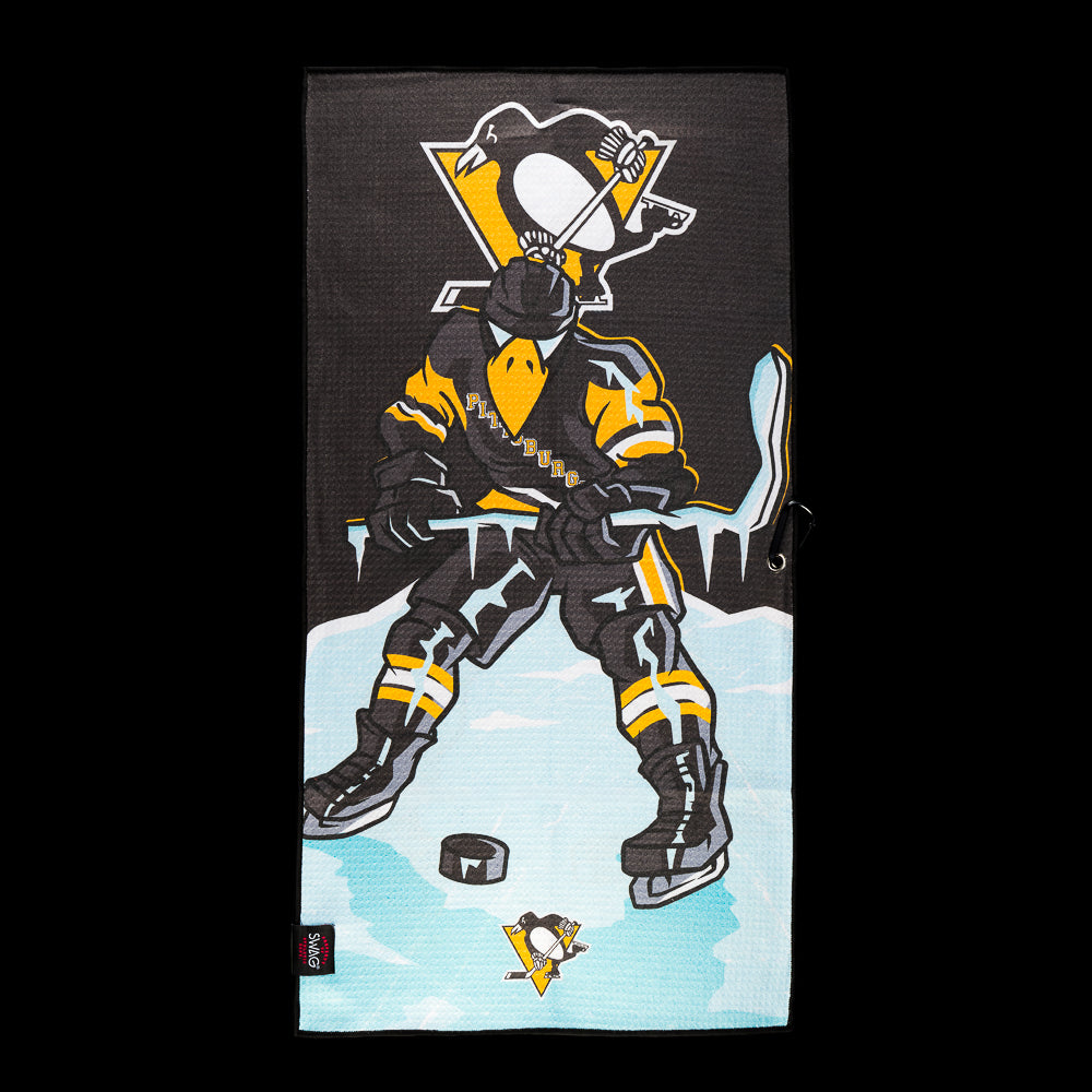 Black and gold Pittsburgh Penguins golf towel with a penguin hockey player with a puck on blue ice and Penguins logo above.