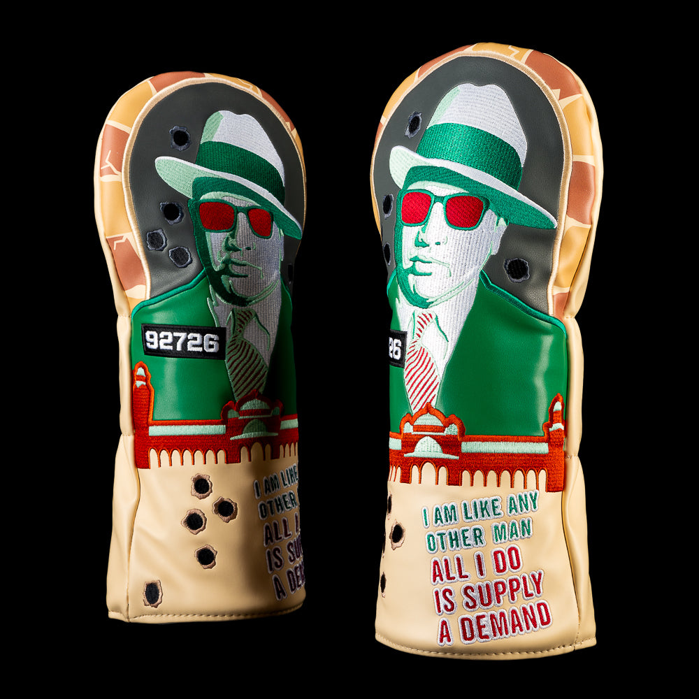 Suburban Capone driver headcover with a green suited figure wearing a fedora and red sunglasses beneath a brick arch with bullet holes.