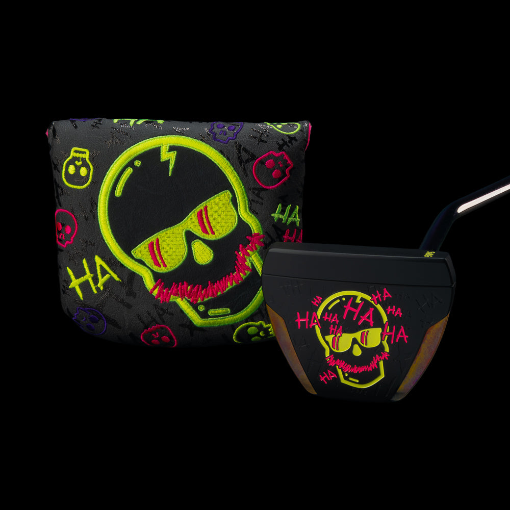 A black golf club headcover and matching putter set against a solid black background. Both pieces feature a neon yellow and pink skull graphic wearing sunglasses, with 'HA HA HA' text and small skull motifs in neon colors on a dark patterned base.