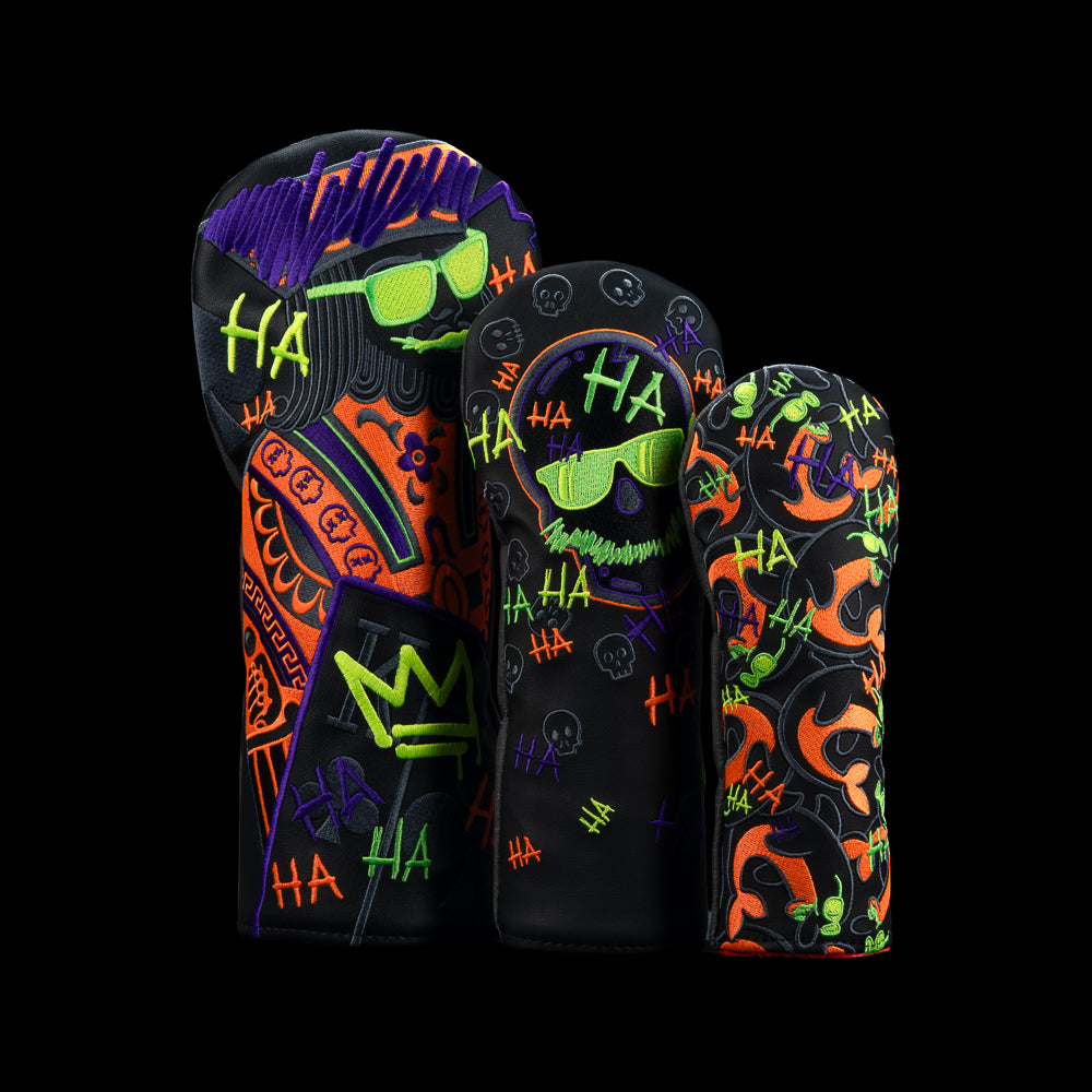 Three black golf headcovers featuring an orange-and-purple king, neon-outlined skull, and orange flipper pattern with colorful graffiti.
