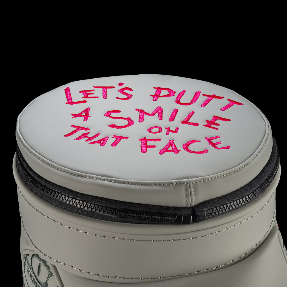 Defaced Franklin Den Caddy Cooler lid with pink “Let’s putt a smile on that face” lettering.