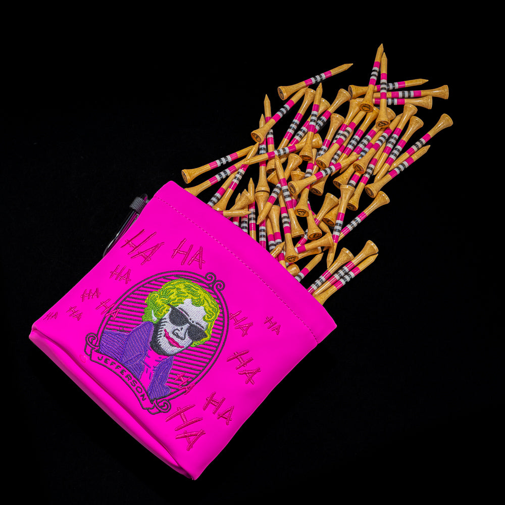 SWAG Golf pink Defaced Jefferson tee pouch with green-haired Jefferson artwork, pink graffiti, and scattered striped wooden golf tees.