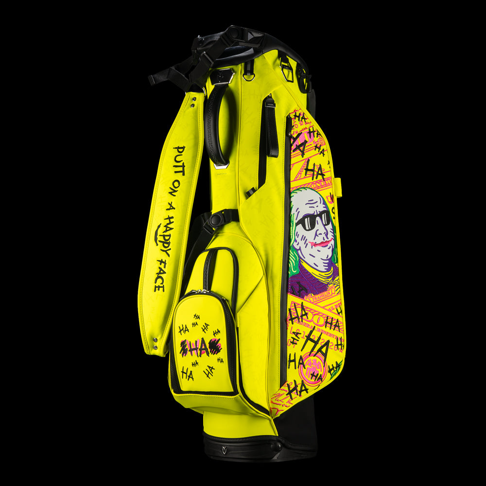 SWAG Golf x Vessel VLS Lux golf stand bag with neon yellow material and embroidered Defaced Franklin design on pink dollar bill themed panels.