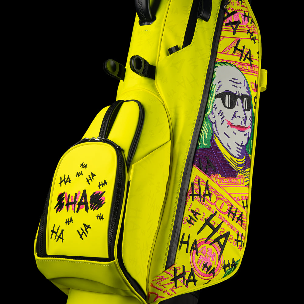 SWAG Golf x Vessel VLS Lux golf stand bag with neon yellow material and embroidered Defaced Franklin design on pink dollar bill themed panels.