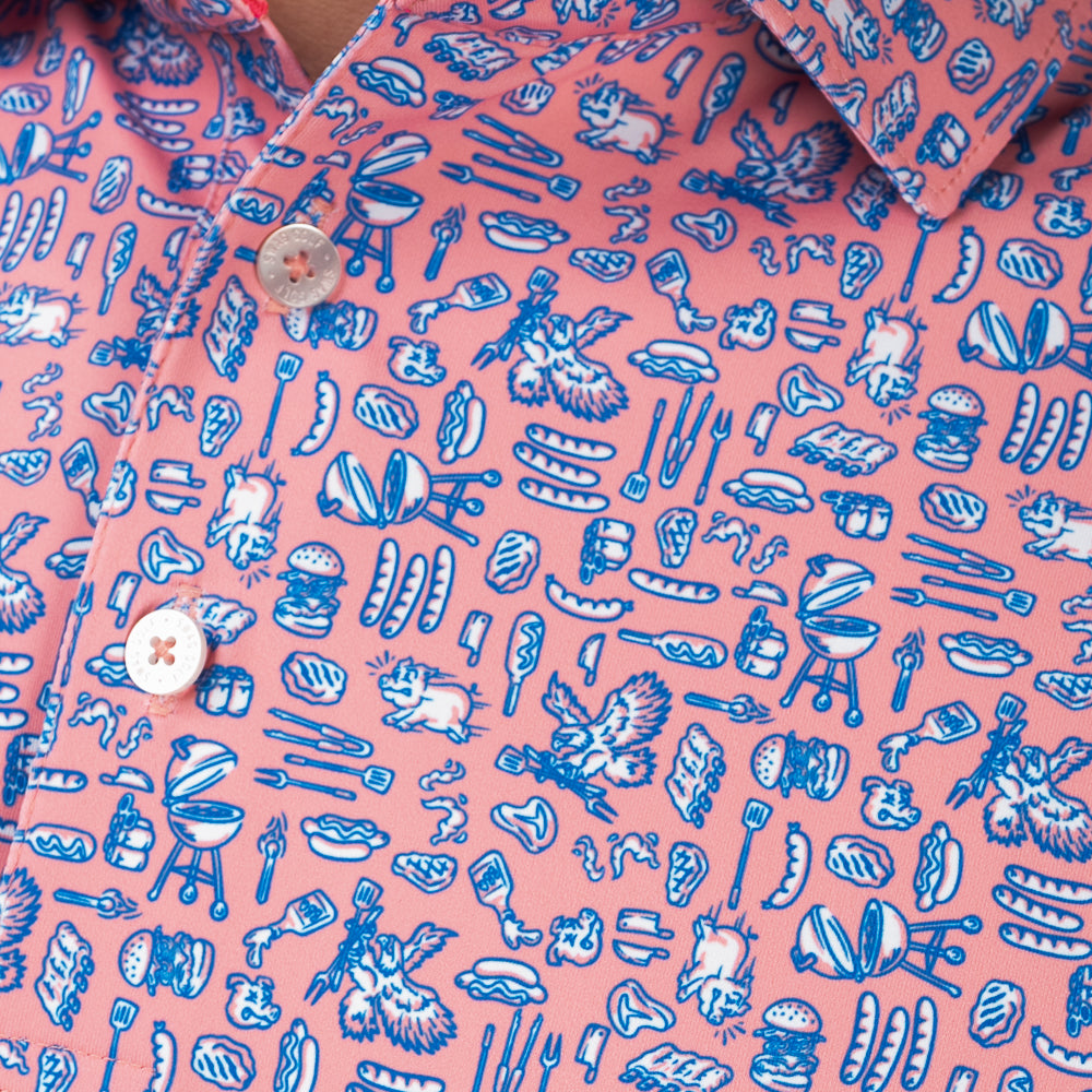 Close-up of SWAG Golf Backyard BBQ Classic Polo highlighting custom artwork featuring barbecue grills, burgers, hot dogs, ribs, grilling tools, and patriotic cookout-inspired icons