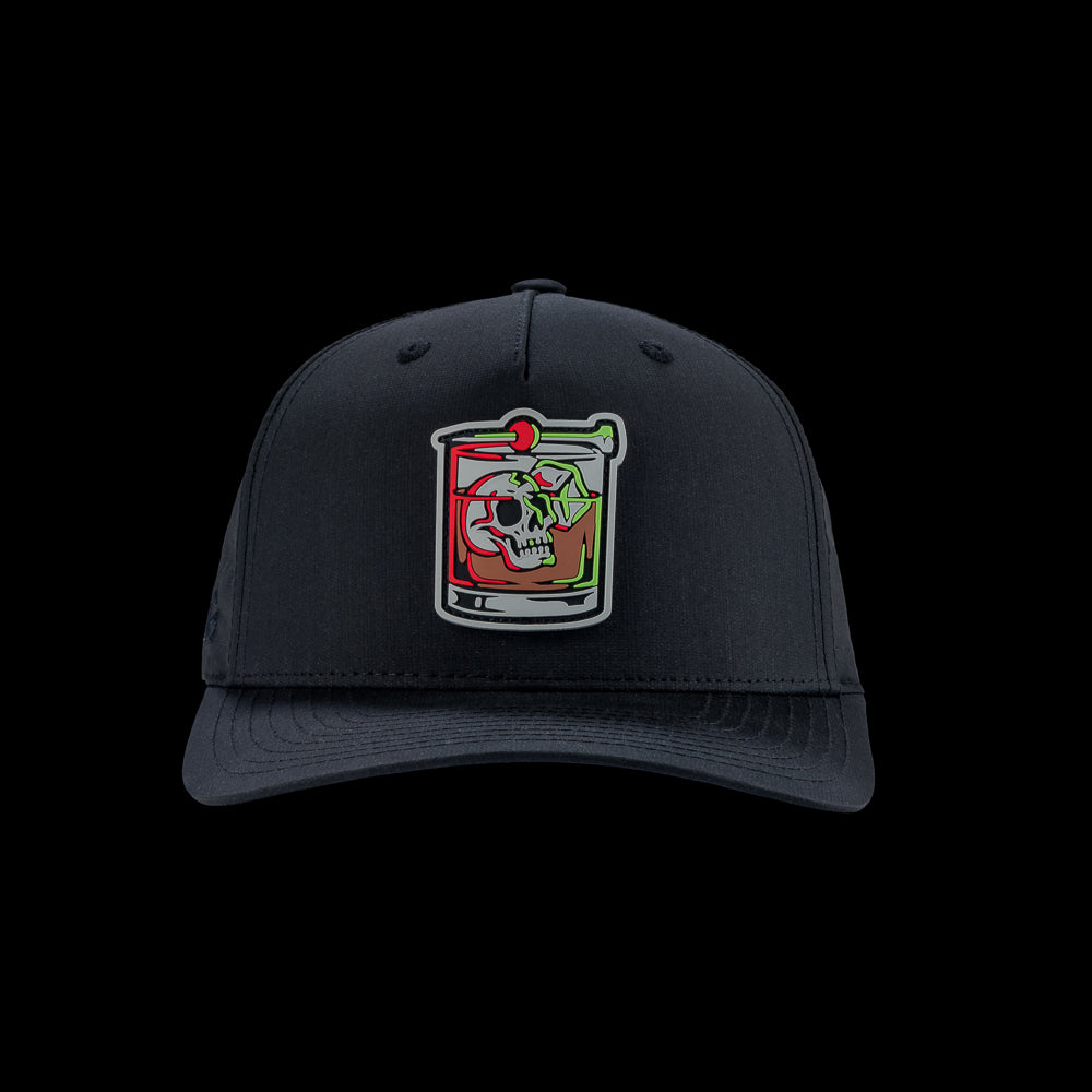 Black performance golf hat with a colorful bourbon glass skull graphic rubber patch on a black background