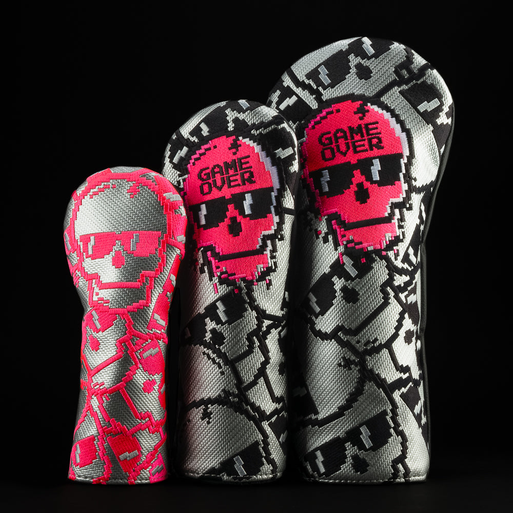 SWAG Golf game over stacked skulls neon pink, gray, and black golf headcover set that includes a driver, fairway, and hybrid.