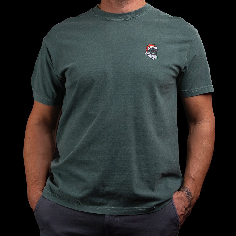 Person wearing a green t-shirt with a Grant meets Santa logo on the chest against a black background