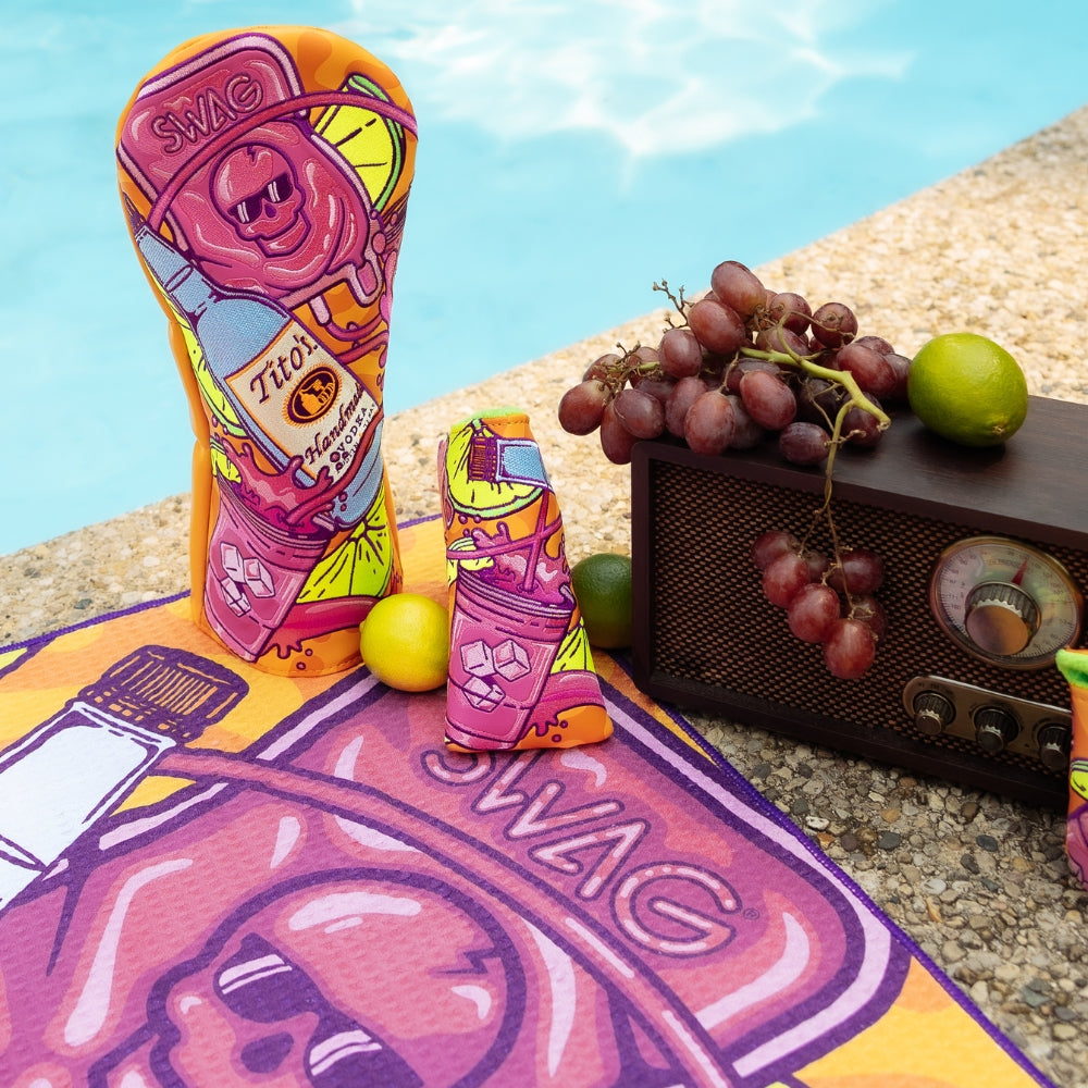 SWAG x Tito's Vodka official golf headcovers featuring splash of grape design in a poolside setting with grapes and limes.