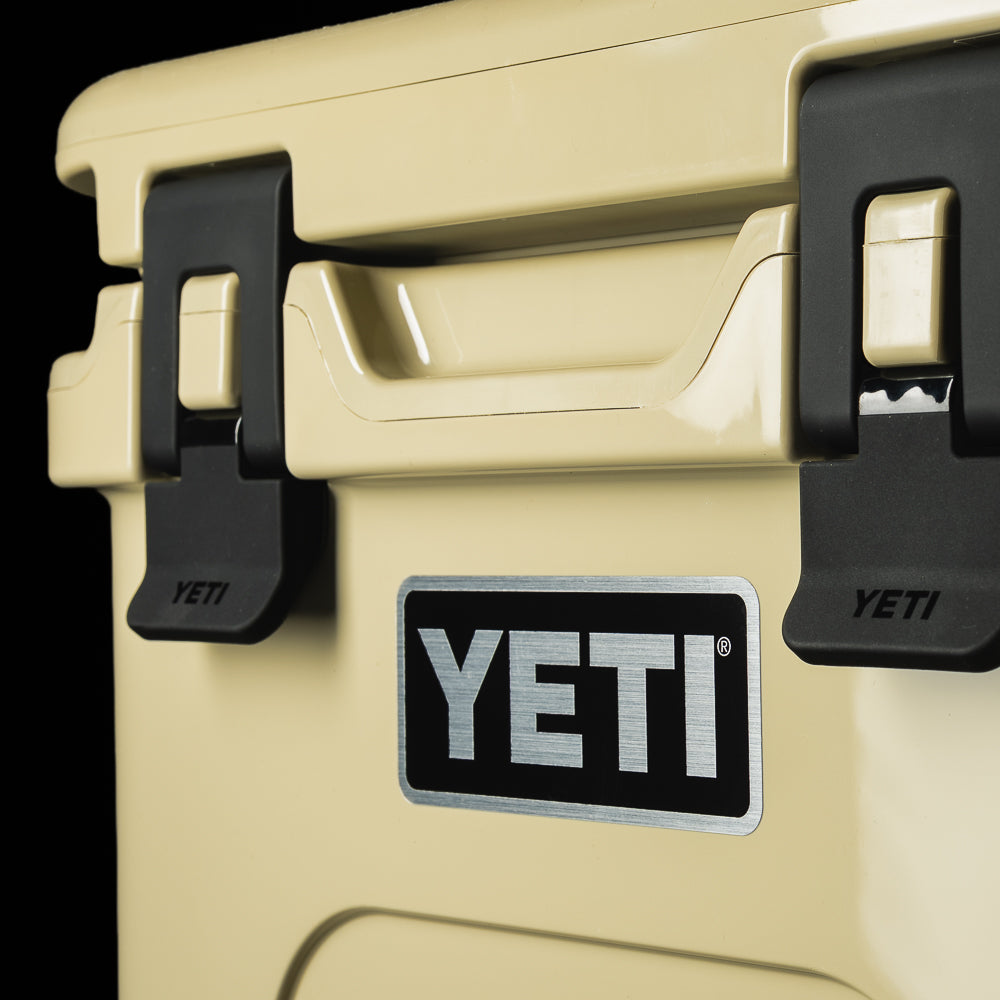 Close-up of the SWAG Golf x YETI cooler front corner highlighting the heavy-duty black latches and tan construction.