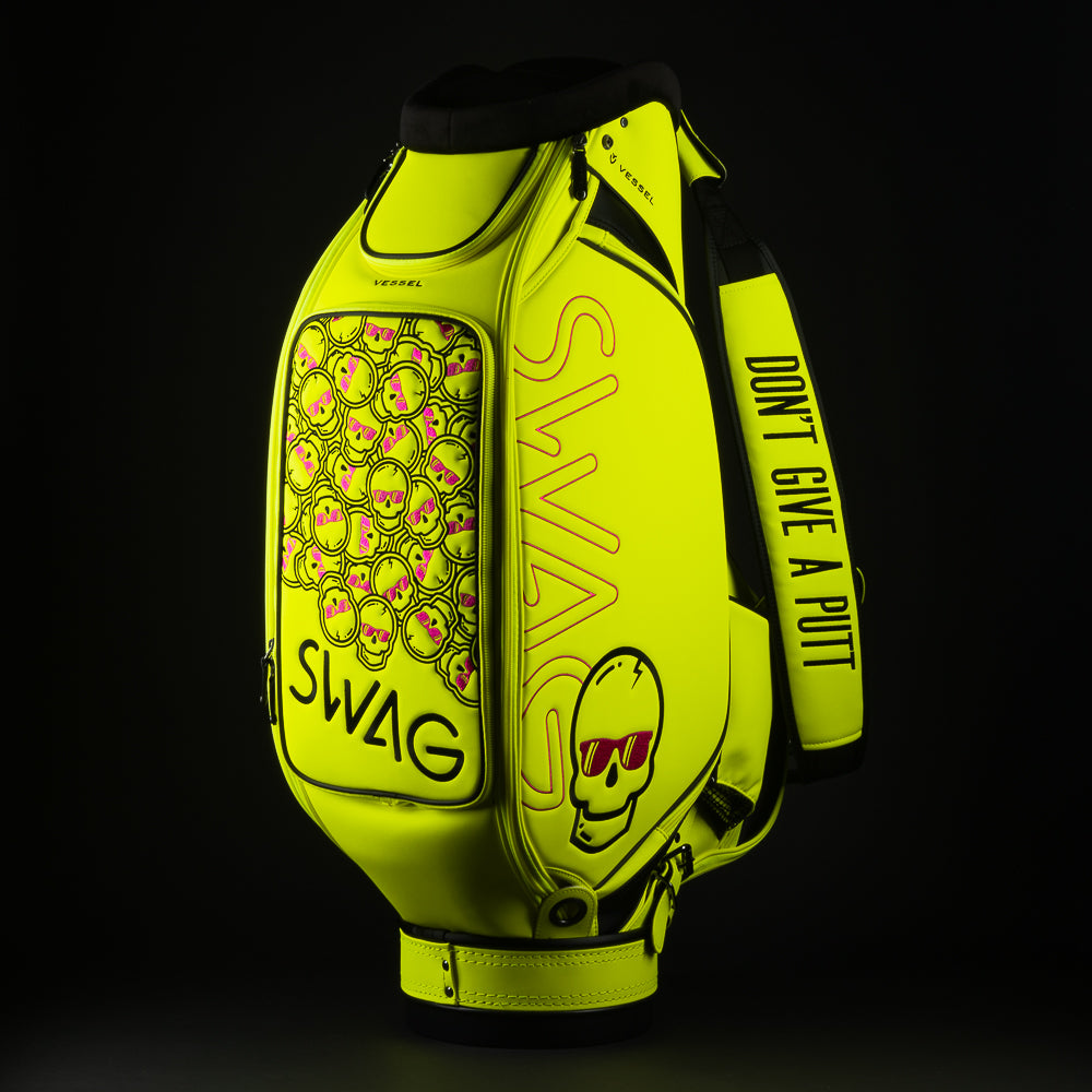 Swag x Vessel tour staff neon yellow golf club bag with stacked pink skulls.