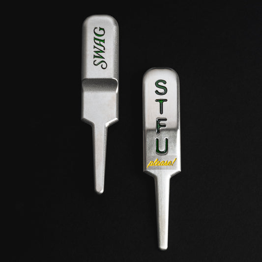 Silver STFU stainless steel golf Divot Tool with green and yellow writing made in the USA.