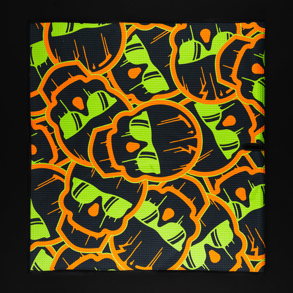 Stacked dripping skulls green and orange golf players towel accessory.