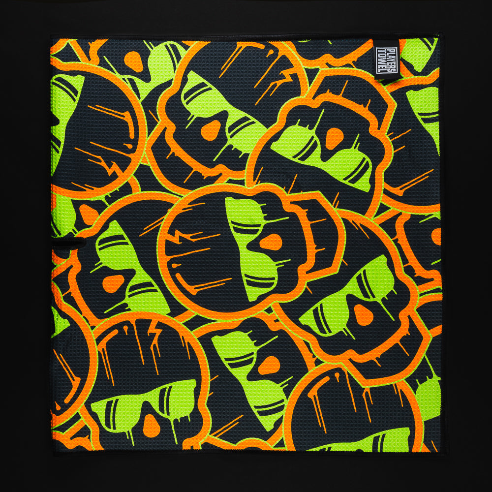Stacked dripping skulls green and orange golf players towel accessory.