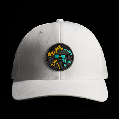 Front view of a white SWAG Thing hat featuring a round multicolor patch with teal, orange, and black graphic artwork.