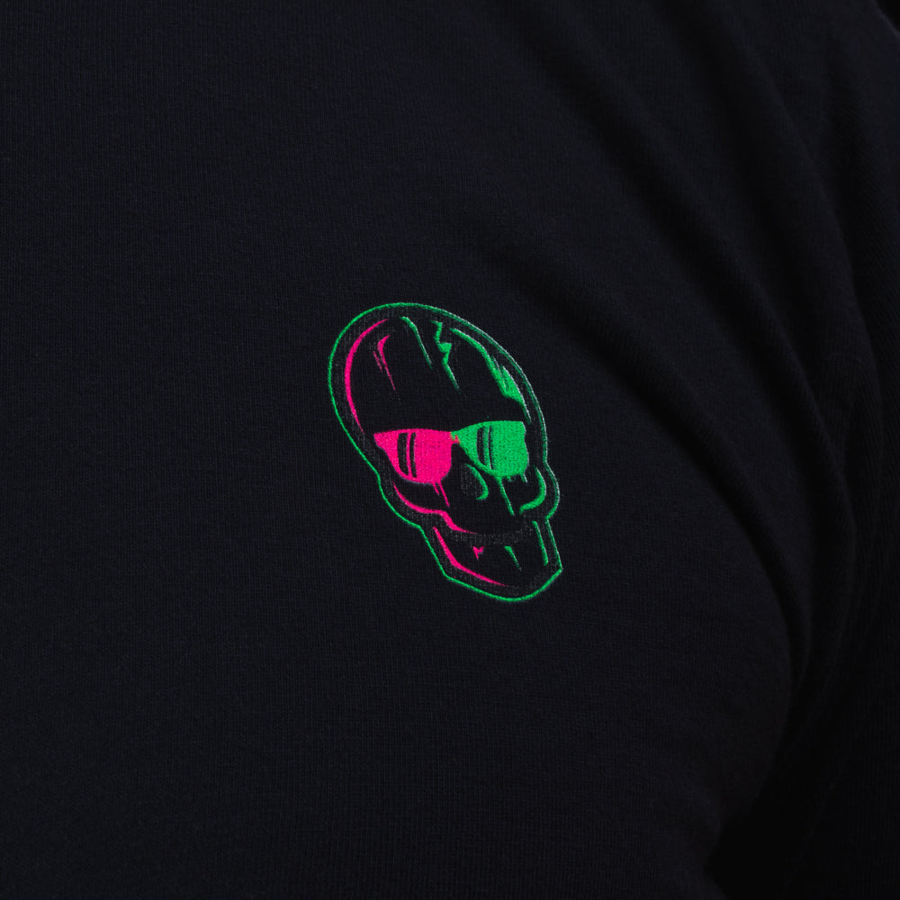 Close-up of the neon green-and-pink SWAG Golf skull logo printed on the black long-sleeve shirt.