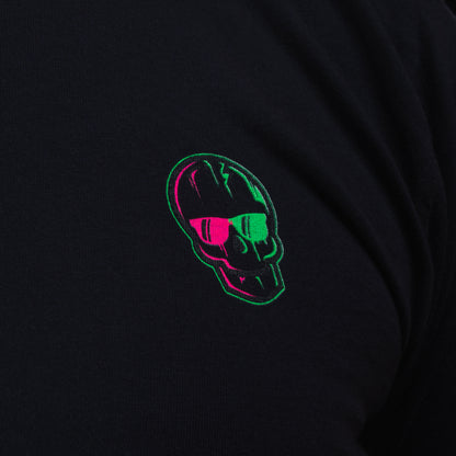 Close-up of the neon green-and-pink SWAG Golf skull logo printed on the black long-sleeve shirt.