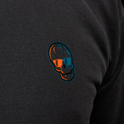 Close-up of the embroidered orange-and-teal SWAG Golf skull logo.