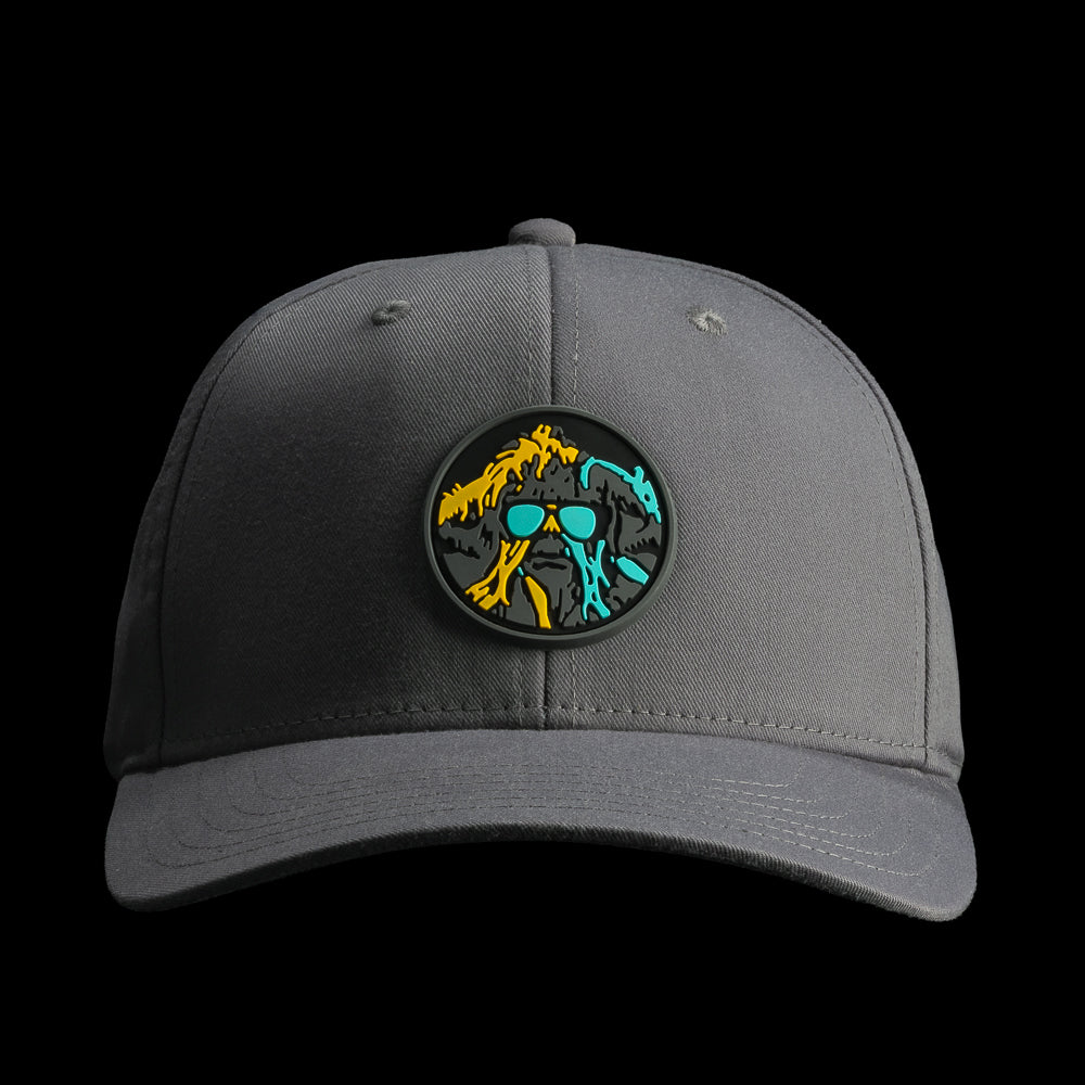 Front view of the grey SWAG Thing golf hat showcasing the circular SWAG Thing logo patch with bold teal, yellow, and black artwork.