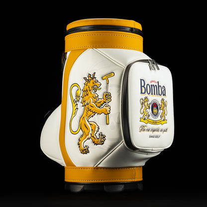 Side view of Bomba Den Caddy golf bag featuring a gold lion holding a putter and a white pocket with Bomba cerveza crest.