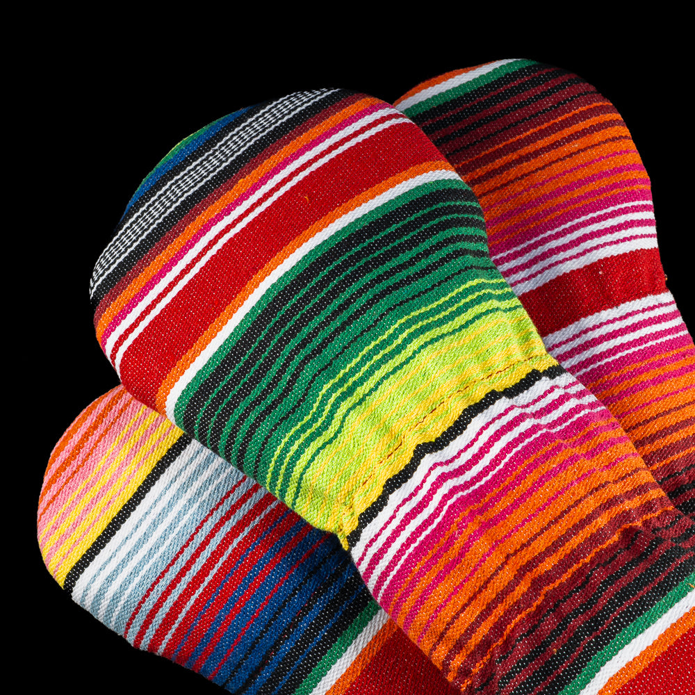 Close-up of colorful striped fabric backs of SWAG Golf headcovers in red, green, yellow, pink, and blue stripes.